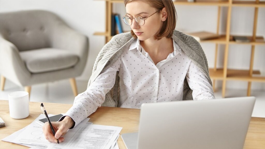 Femeie care completează un certificat de rezidență fiscală Germania.